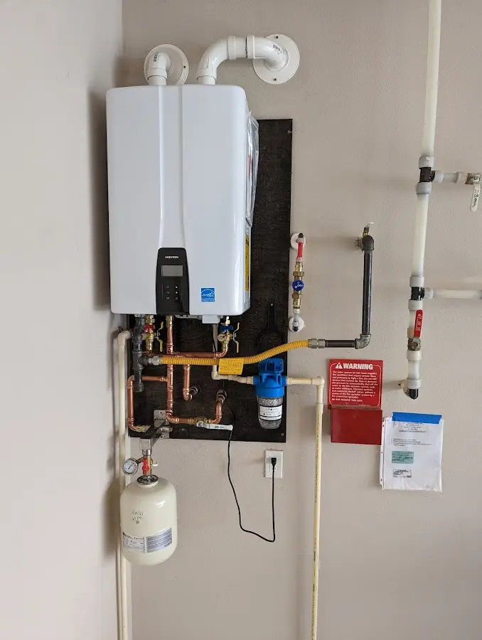Professional plumber installing copper piping in a Hermantown home